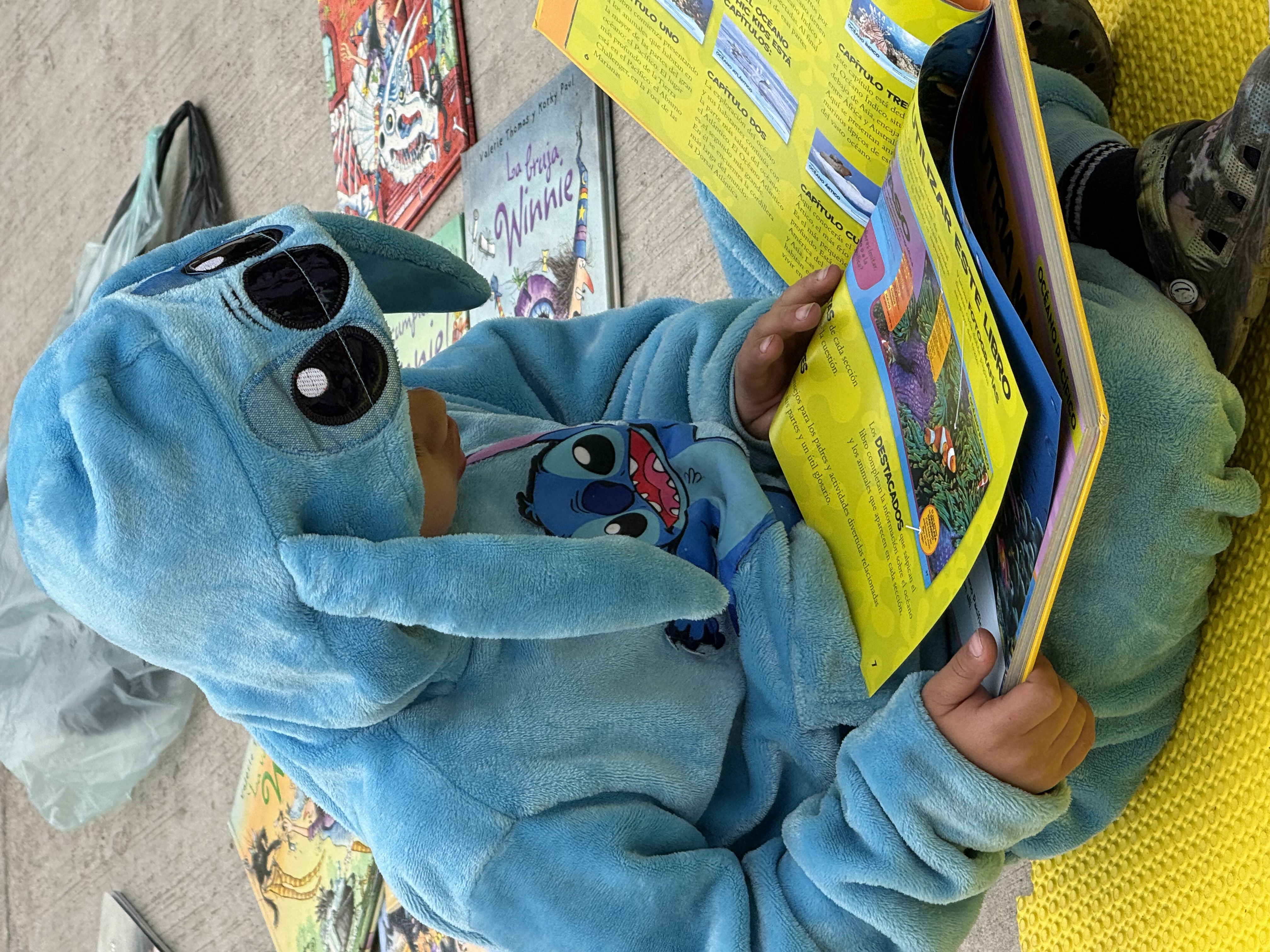 A child reading a book on the ground